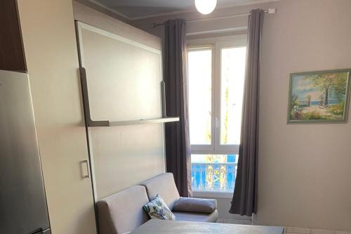 un salon avec une chaise et une fenêtre dans l'établissement Apartment 2 rooms with Wifi in the heart of Nice, à Nice