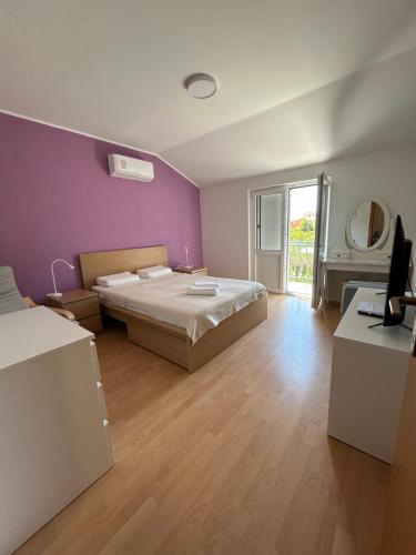 a bedroom with a bed and a purple wall at Apartment Kix in Rab