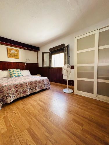 a bedroom with a bed and a fan at Neptuno 12 in Caleta De Fuste