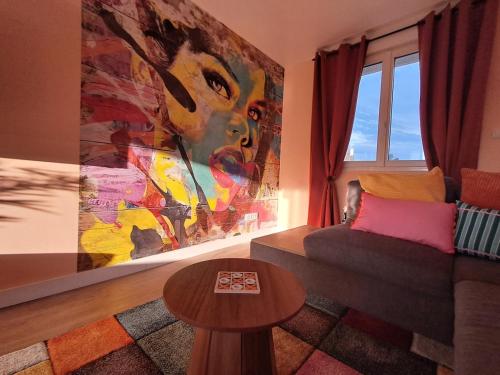 a living room with a couch and a large painting at Suite Bretagne - Billard, Spa, Ciné- Proche Lorient in Plouay