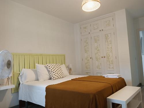 a bedroom with a bed with a brown blanket at Apartamento Exterior Camino Inglés # a 10 min de Santiago in Sigüeiro