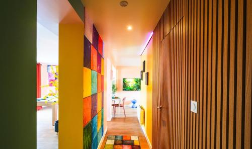 a hallway with a rainbow colored wall in a house at Suite Bretagne - Billard, Spa, Ciné- Proche Lorient in Plouay