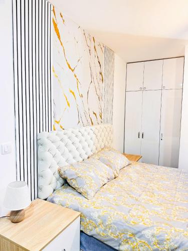 a bedroom with a bed with a white headboard at Penthouse Studio Borovi in Divčibare