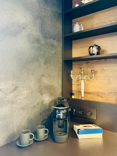a coffee maker and two cups on a table at Parko namai-loftas in Kaunas