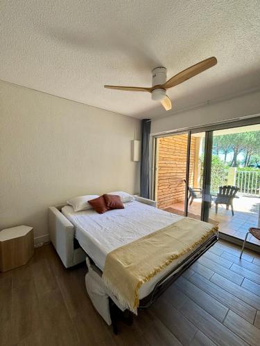 une chambre avec un lit et un ventilateur de plafond dans l'établissement Studio avec jardin front de mer, à Argelès-sur-Mer