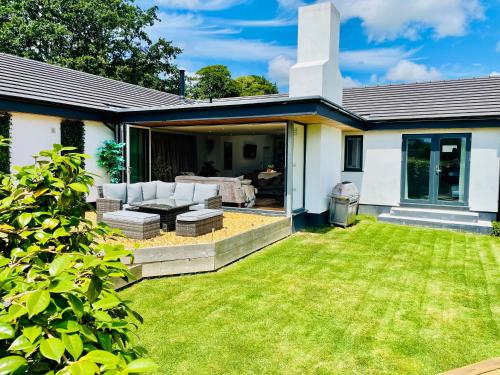 a backyard of a house with a lawn at The Cuckoo's Retreat - Luxurious home with private garden & jacuzzi in Kenwyn