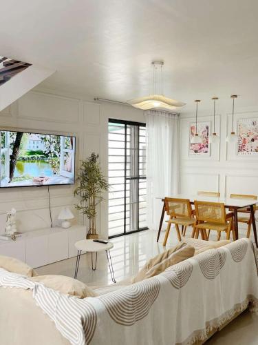 a living room with a couch and a table at Maison de Jacinta - 2BR HOUSE NEAR AGUINALDO HIGHWAY in Dasmariñas