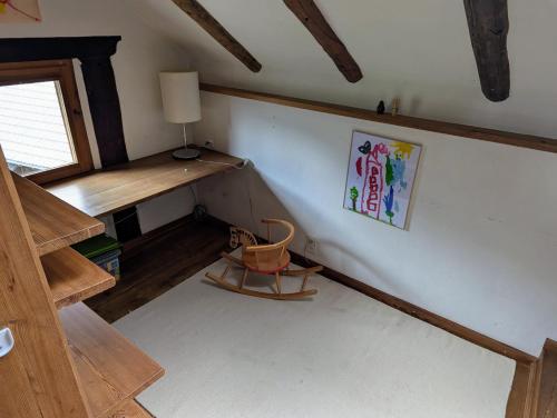 an attic room with a desk and a chair at Cosy Wooden Home in the Swiss Alps in Cavagnago