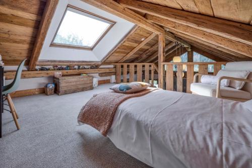 une chambre avec un grand lit dans un grenier dans l'établissement AO HOUSE - PRAKKA High Camp, aux Houches