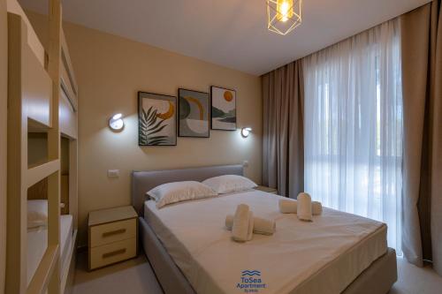 a bedroom with a bed with white sheets and a window at ToSea Apartment by Melia in Lalzit Bay