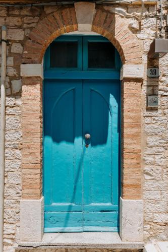 a blue door in a building with an arch at Borgo delle Fonti in Acquaviva Collecroce