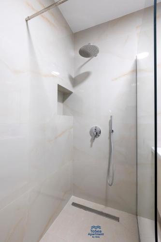 a bathroom with a shower with a glass door at ToSea Apartment by Melia in Lalzit Bay