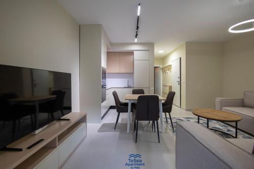 a living room and kitchen with a table and chairs at ToSea Apartment by Melia in Lalzit Bay