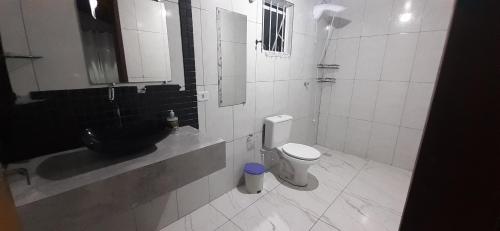a bathroom with a black sink and a toilet at A Casa TOP da Região in Matinhos