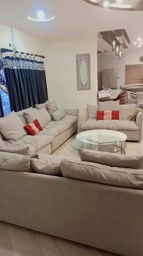 a living room with two couches and a table at Peaceful Hilltop Apartment in Changla Gali in Chhāngla Gali