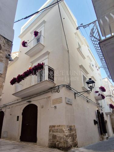a building with two balconies and flowers on it at Le Cinque Lune in Vieste