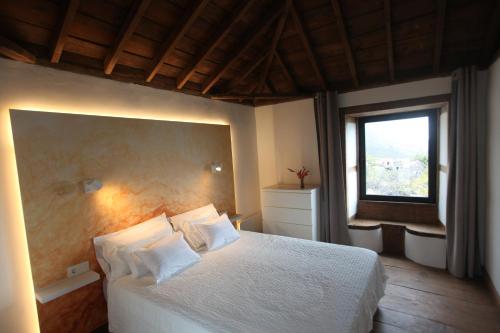 a bedroom with a white bed and a window at ATALAYA - PISCINA PRIVADA - agua calentada- ADULTS ONLY in Lomo Machín