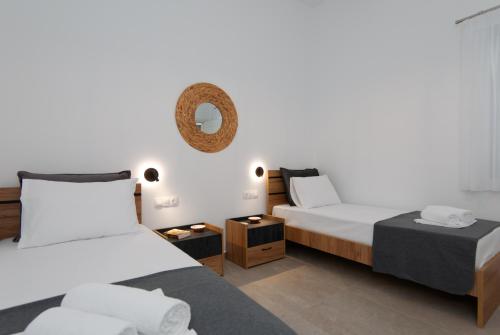 a bedroom with two beds and a mirror at Θεμωνιά house in Káto Petálion