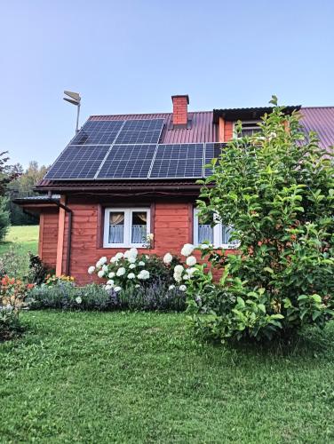 a house with solar panels on the roof at Domek Gajowego in Ropienka