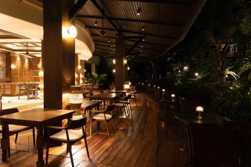 a restaurant with tables and chairs on a wooden floor at Pakasai Resort in Ao Nang Beach