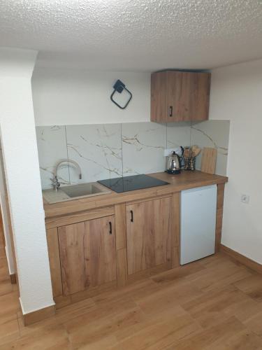 a kitchen with wooden cabinets and a sink at Apartamenty Zator Energy Rest in Zator