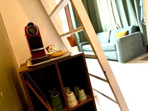 a room with a ladder and a table with a mirror at Cosy Studio, with outdoor swimming in Amsterdam