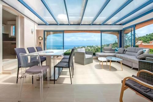 un salon avec une table, des chaises et un canapé dans l'établissement CASA-Capussambre spacious villa with sea view heated pool air con sauna Les Issambres, aux Issambres