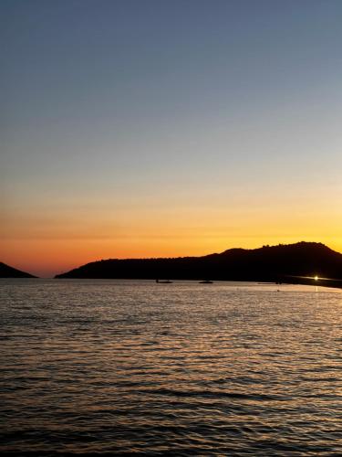a sunset over the water with mountains in the background at Villa Gaia Navarino in Korifásion