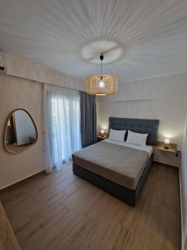 a bedroom with a bed and a mirror and a chandelier at CELENI APARTMENTS in Lefkada