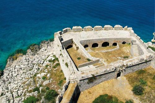 an old building on a cliff next to the ocean at Villa Gaia Navarino in Korifásion