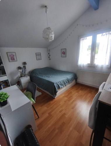 une chambre avec un lit, une table et une fenêtre dans l'établissement Chambre cosy dans une élégante maison à Pornic, à Pornic