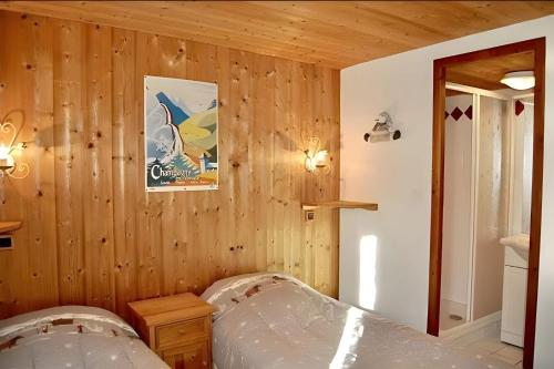 - une chambre avec des murs lambrissés et un lit dans l'établissement Casa-Chalet du Torchet luxury chalet stunning view, à Champagny-en-Vanoise