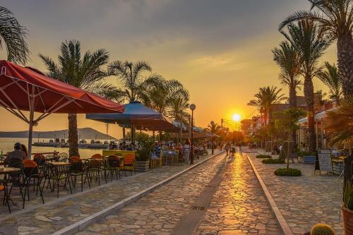 a street with tables and chairs and the sunset at Villa Gaia Navarino in Korifásion