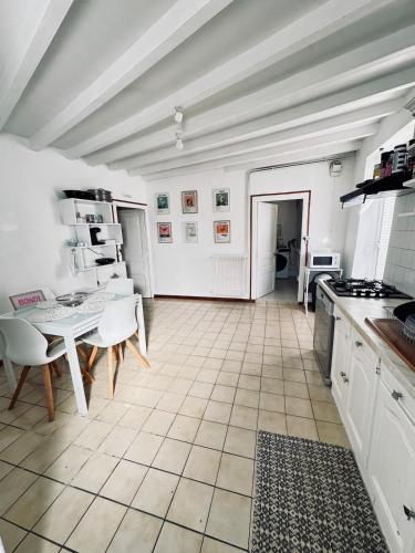 Cozy house في Benon: مطبخ به طاولة وكراسي في غرفة