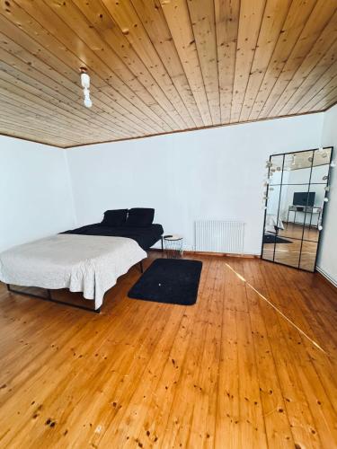 Cozy house في Benon: غرفة نوم مع سرير وأرضية خشبية