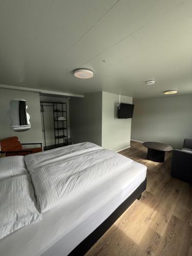 a bedroom with a large white bed and a couch at Hótel Gerpir in Neskaupstaður