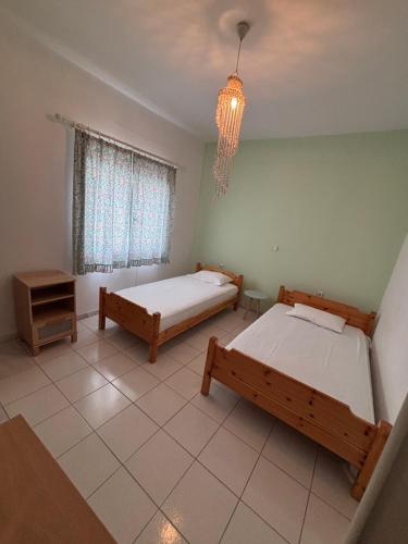 a bedroom with two beds and a chandelier at Pebble Sea House in Orfánion