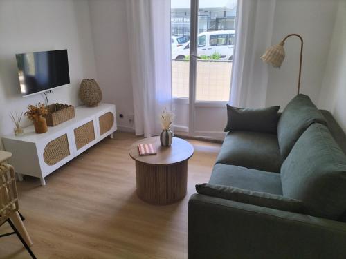 a living room with a couch and a coffee table at Appartement Grande Plage St Gilles Croix de Vie - Parking privé in Saint-Gilles-Croix-de-Vie