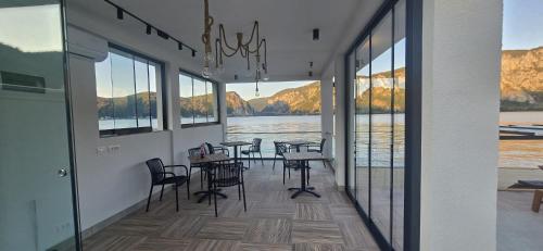 a dining room with tables and chairs and a view of the water at Harmony House - Adults Only in Dubova