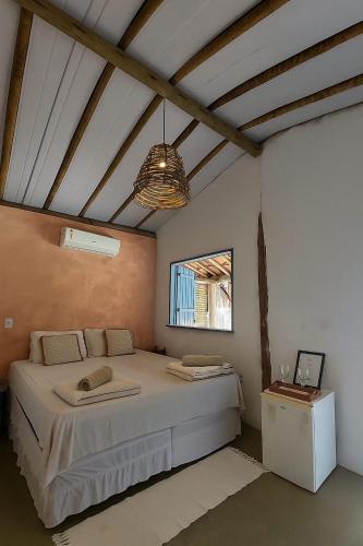 ein Schlafzimmer mit einem großen Bett und einem Fenster in der Unterkunft Quintal do Céu Caraíva in Caraíva