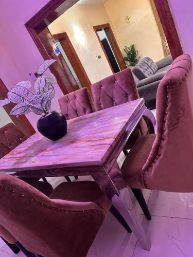 a dining room table with chairs and a mirror at Greenland Homes and apartment in Akure