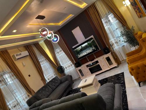 a living room with a couch and a flat screen tv at Greenland Homes and apartment in Akure
