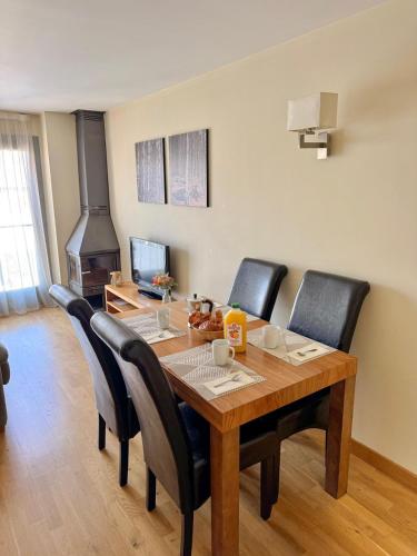 une salle à manger avec une table en bois et des chaises noires dans l'établissement Résidence CERDANYA, à Bourg-Madame