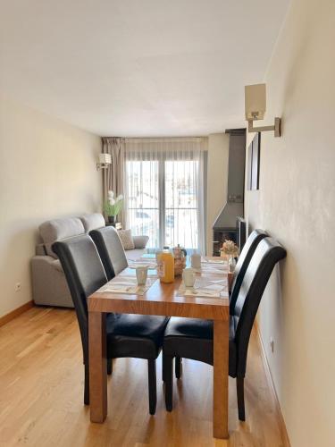 une salle à manger avec une table en bois et des chaises noires dans l'établissement Résidence CERDANYA, à Bourg-Madame