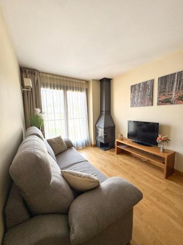 un salon avec un canapé et une cheminée dans l'établissement Résidence CERDANYA, à Bourg-Madame