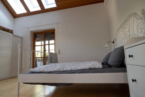 a bedroom with a bed in a white room at Ferienhaus Fischermartl am Ammersee in Dießen am Ammersee