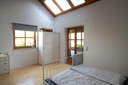 a bedroom with a bed and a window at Ferienhaus Fischermartl am Ammersee in Dießen am Ammersee