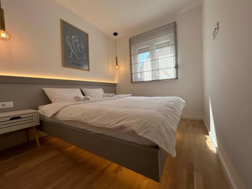 a bedroom with a large bed with a window at La Paloma Blanca in Tuzla
