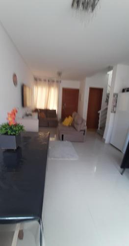 a large living room with a couch and a table at Casa aconchegante na praia na praia da Enseada in Guarujá