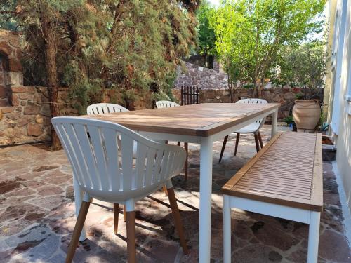 a wooden table and chairs on a patio at new serenity villa aegina in Aegina Town